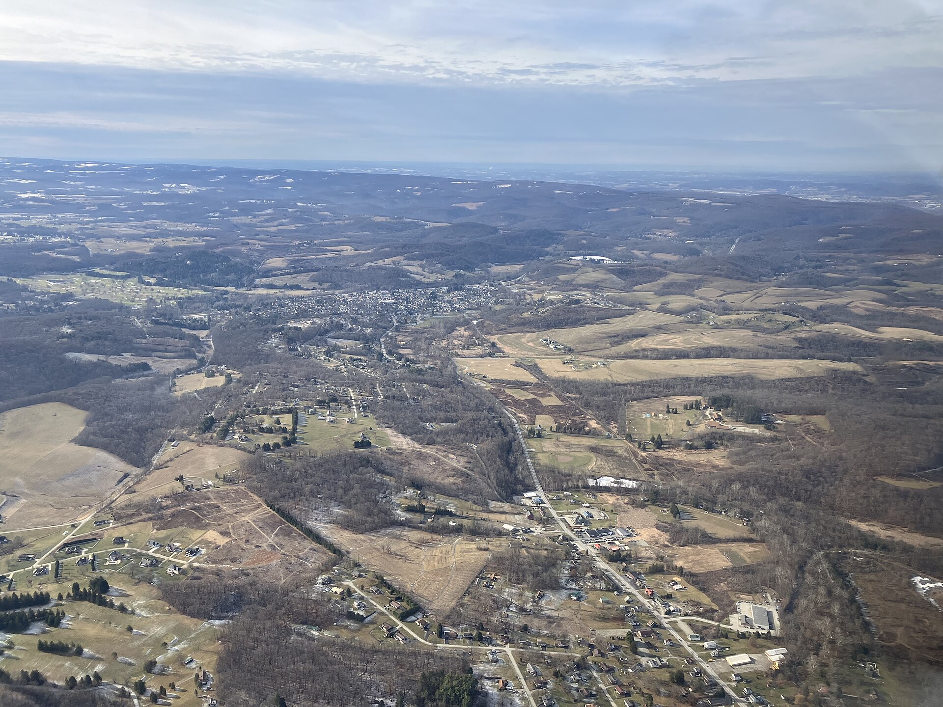 Aerial view of the Ligonier valley in winter, fields and roads stretching to the ridges